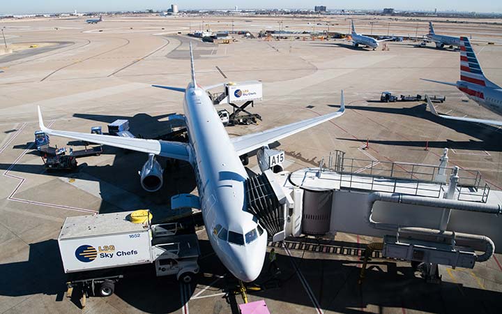 airplane attached to jetway at gate