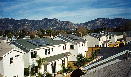 Residential houses with solar panels and a mountain range in the background