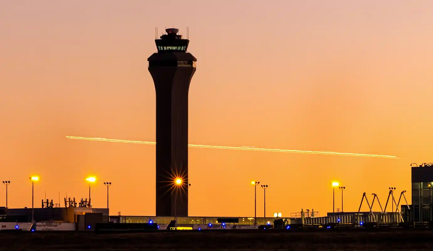 An airport air traffic control tower at sunset