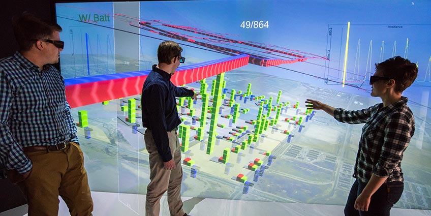 Researchers look at a 3D building model in the visualization lab at NREL.