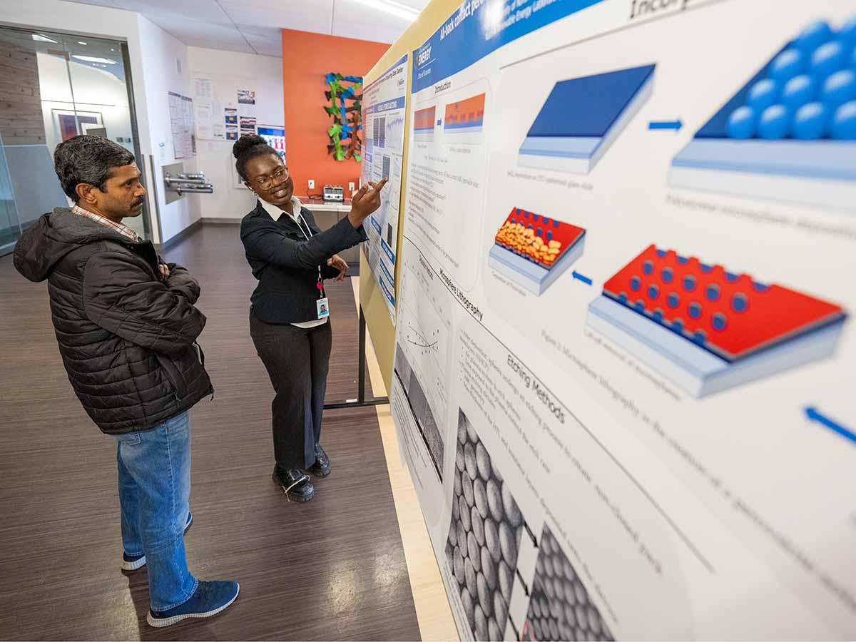 Researchers review a technical poster.