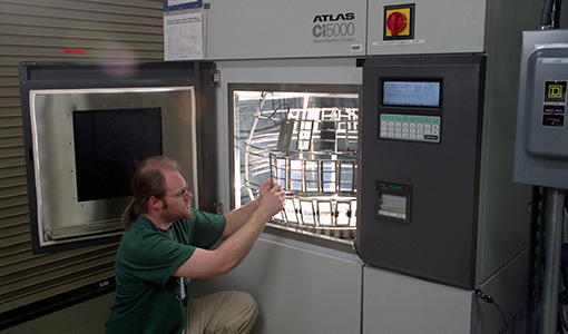 Technician loading samples into an Atlas Ci5000 xenon arc weathering/lightfastness test chamber.