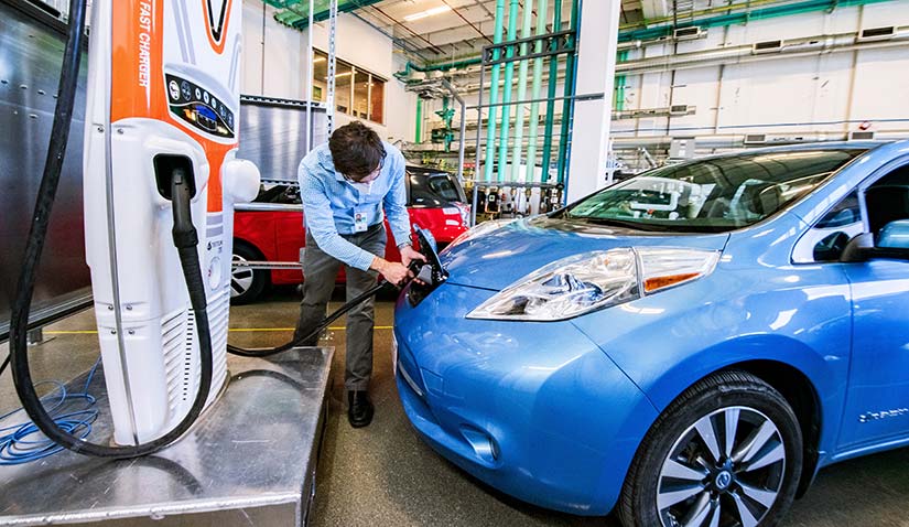 advanced-mobility-62139 Photo of a researcher plugging in an electric vehicle in a laboratory in the ESIF.
