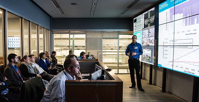 standards-codes-41155 An NREL researcher presents on an electrolyzer grid integration demonstration in the control room of the Energy Systems Integration Facility.