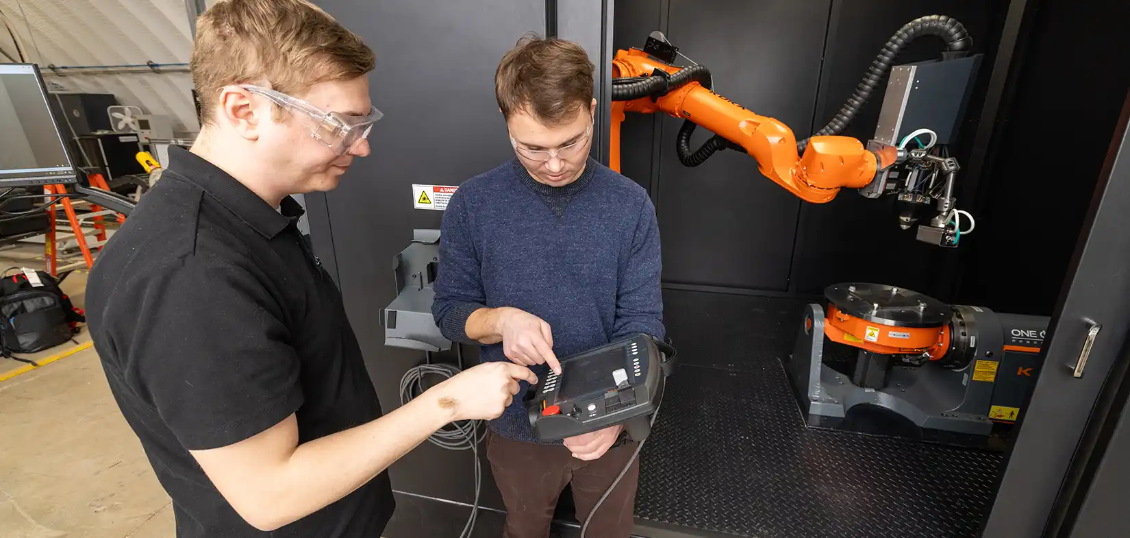 Two researchers looking at a handheld controller.