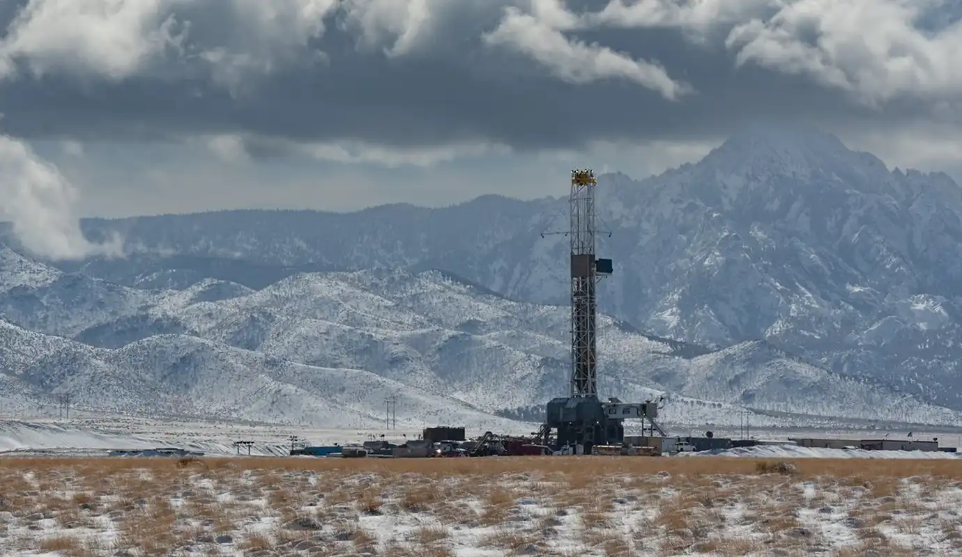 A geothermal station with clouds and mountains in the background.