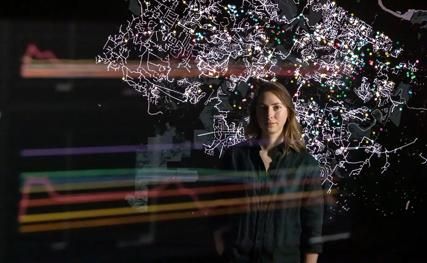 A person stands in front of a screen visualizing an energy grid map.