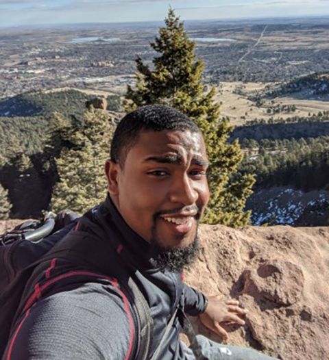 A person taking a selfie on a mountaintop.