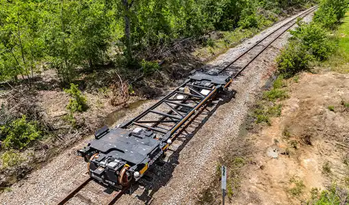 An unloaded automated rail vehicle propels itself down rail tracks in the state of Georgia.