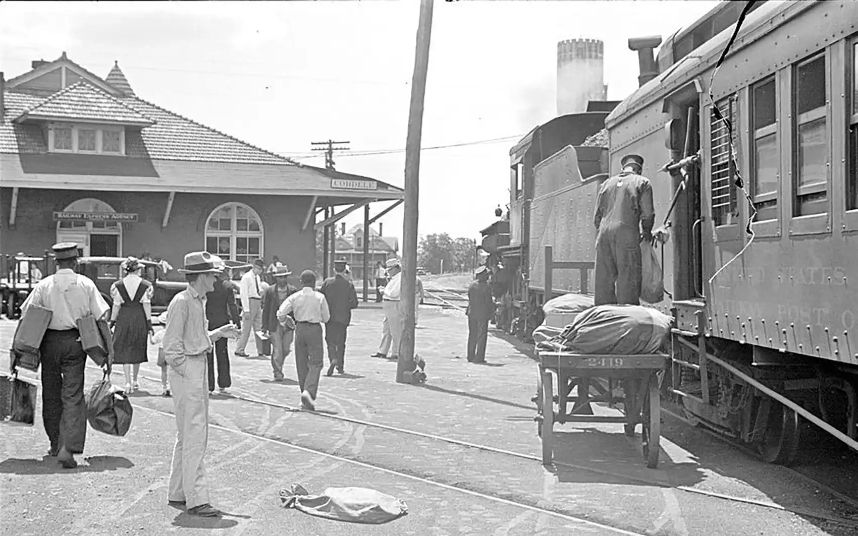 A bustling crowd alongside a freight train at the railroad station in Cordele, Georgia, in May 1938, pictured in a black-and-white photograph.