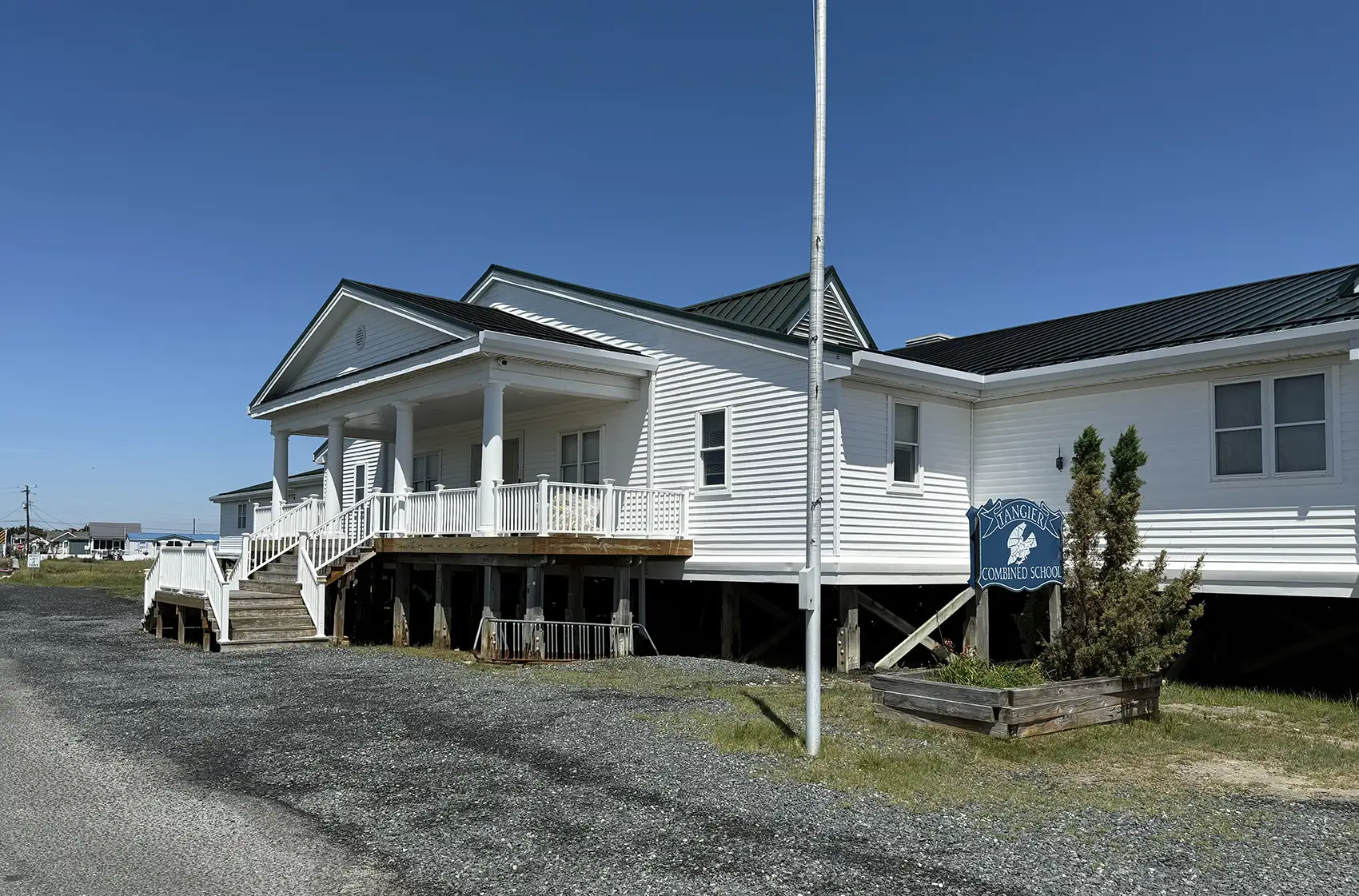 A building with a sign in front of it that reads Tangier Combined School.