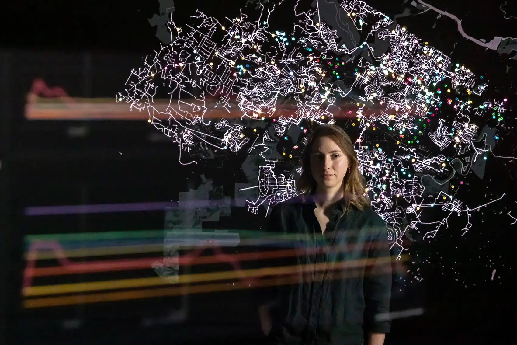 A person in the reflection of a screen with a map on it.