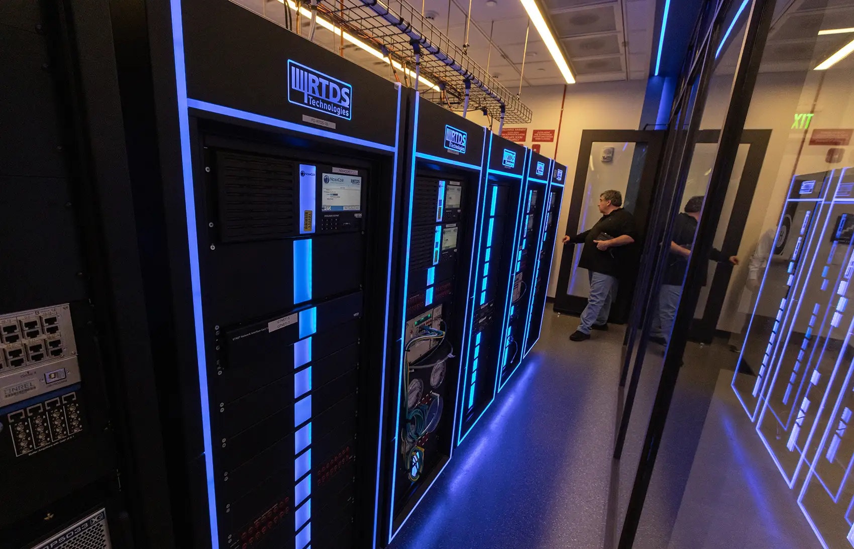 A person stands next to a supercomputer.