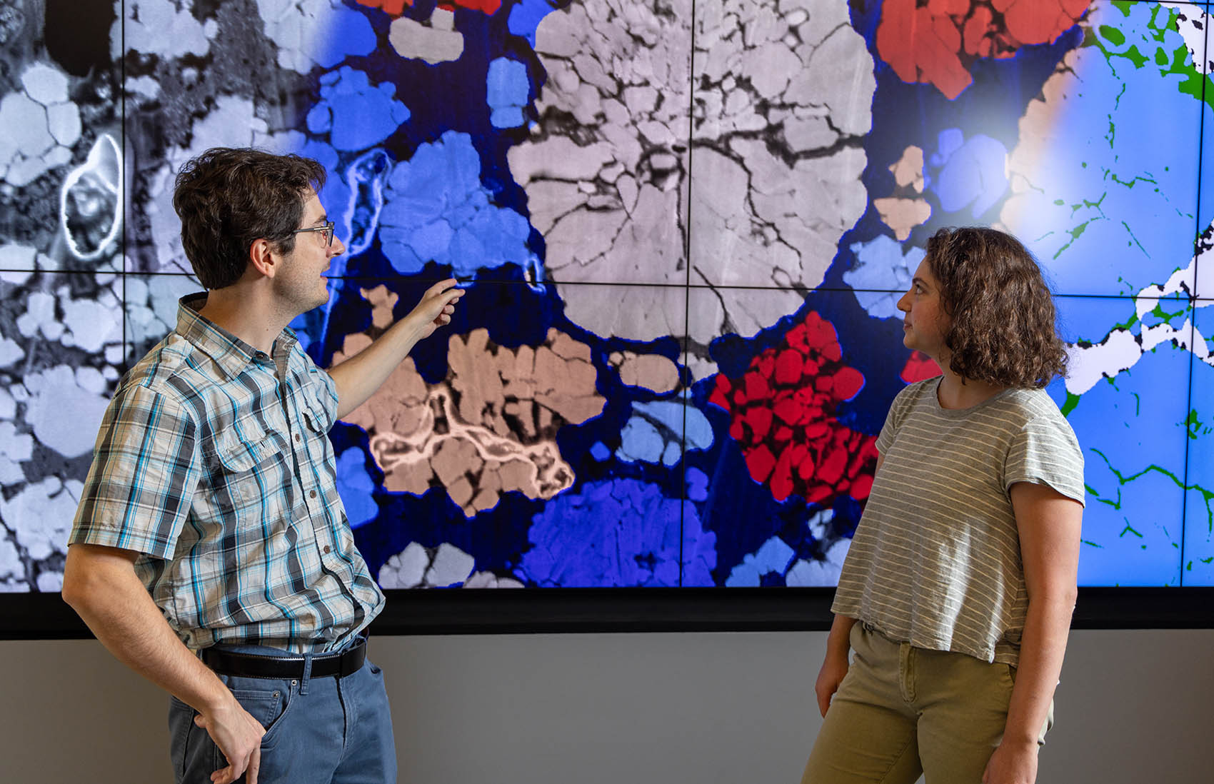 20260624-cradle-to-crisis-approach-improves-battery-safety-and-performance-093997 Two people point and look at an image on a large screen.