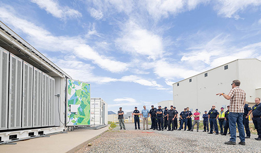 Continue reading about A group of first responders stand outside near a battery energy storage system.
