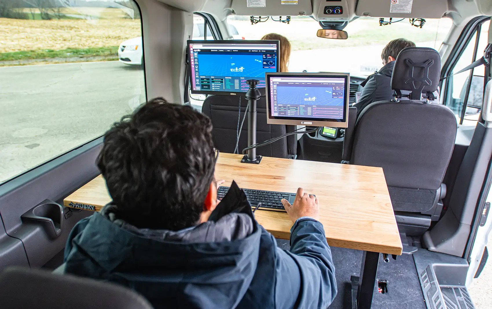 20261021-super-intelligence-speeds-up-transportation-research-at-national-laboratory-of-the-rockies-100533 An engineer in the back of a truck monitors a connected truck’s progress on several computer screens.