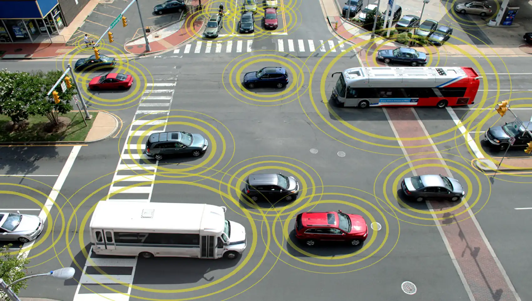 20261021-super-intelligence-speeds-up-transportation-research-at-national-laboratory-of-the-rockies-topdown-traffic Vehicles surrounded by digitally generated rings cross a busy intersection, signifying that they are visible to smart traffic infrastructure.