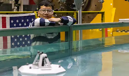 A person standing near a tank of water.