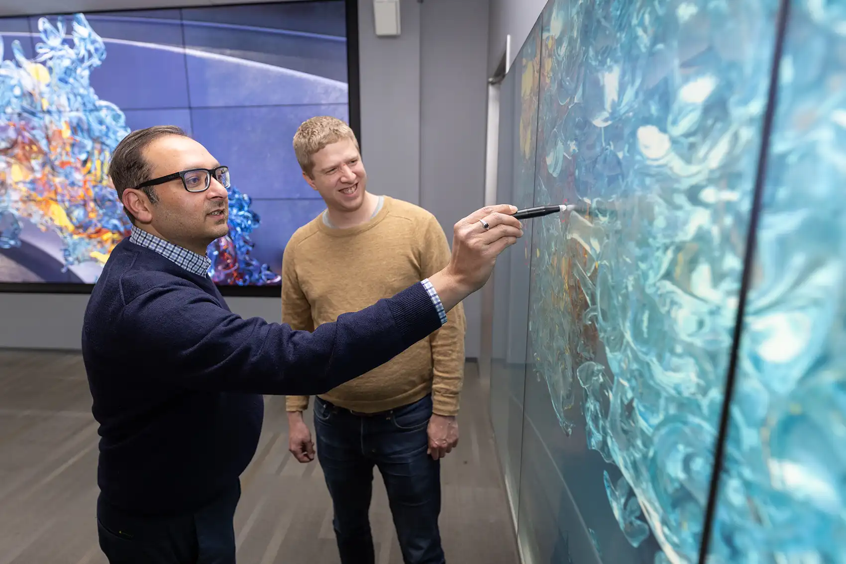 Two researchers look at a combustion simulation.