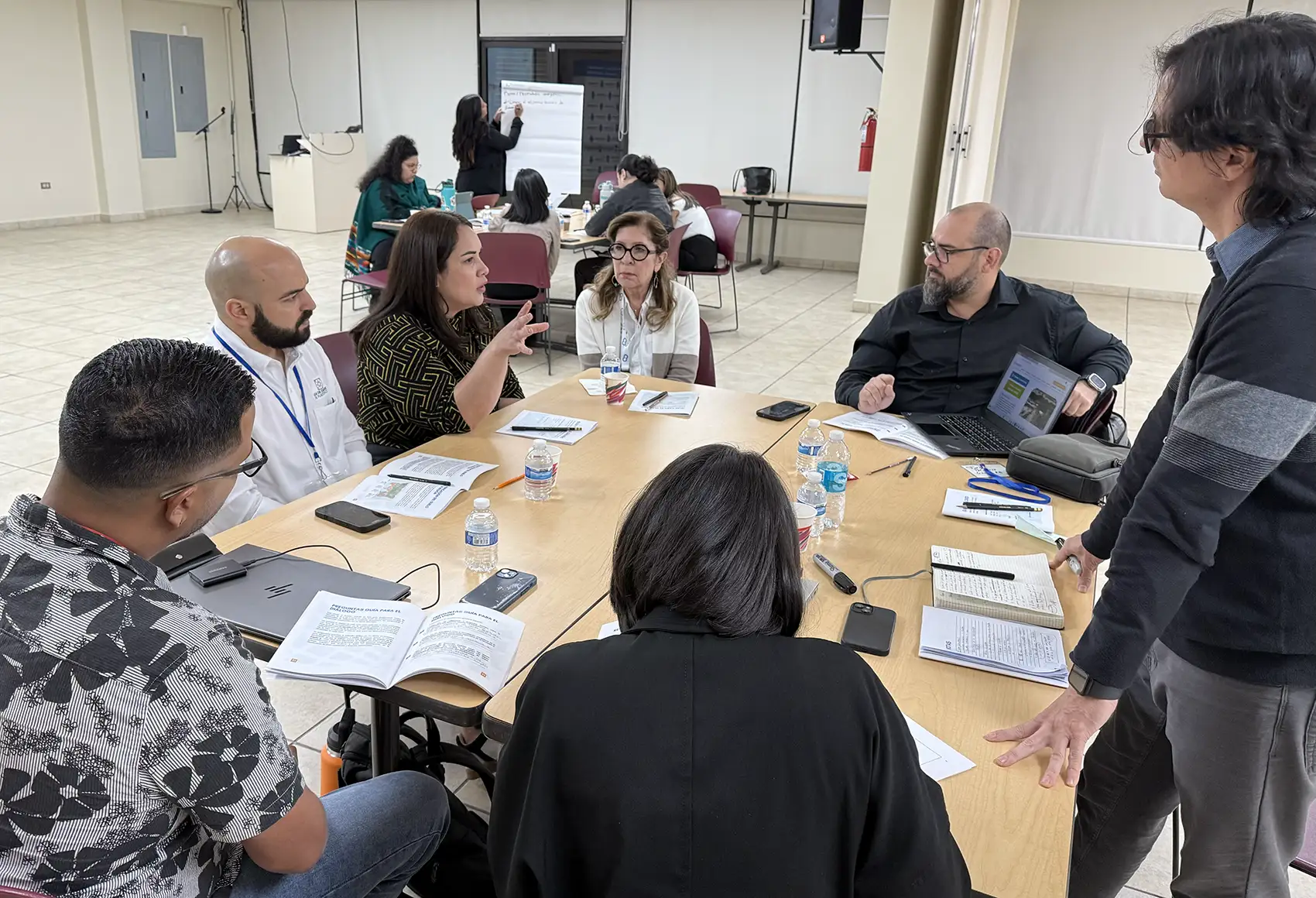 20260224-beneath-the-surface-glorynel-ojeda-matos-on-strengthening-the-systems-we-depend-on-regional-workshops A group of people gathered around a table to converse.