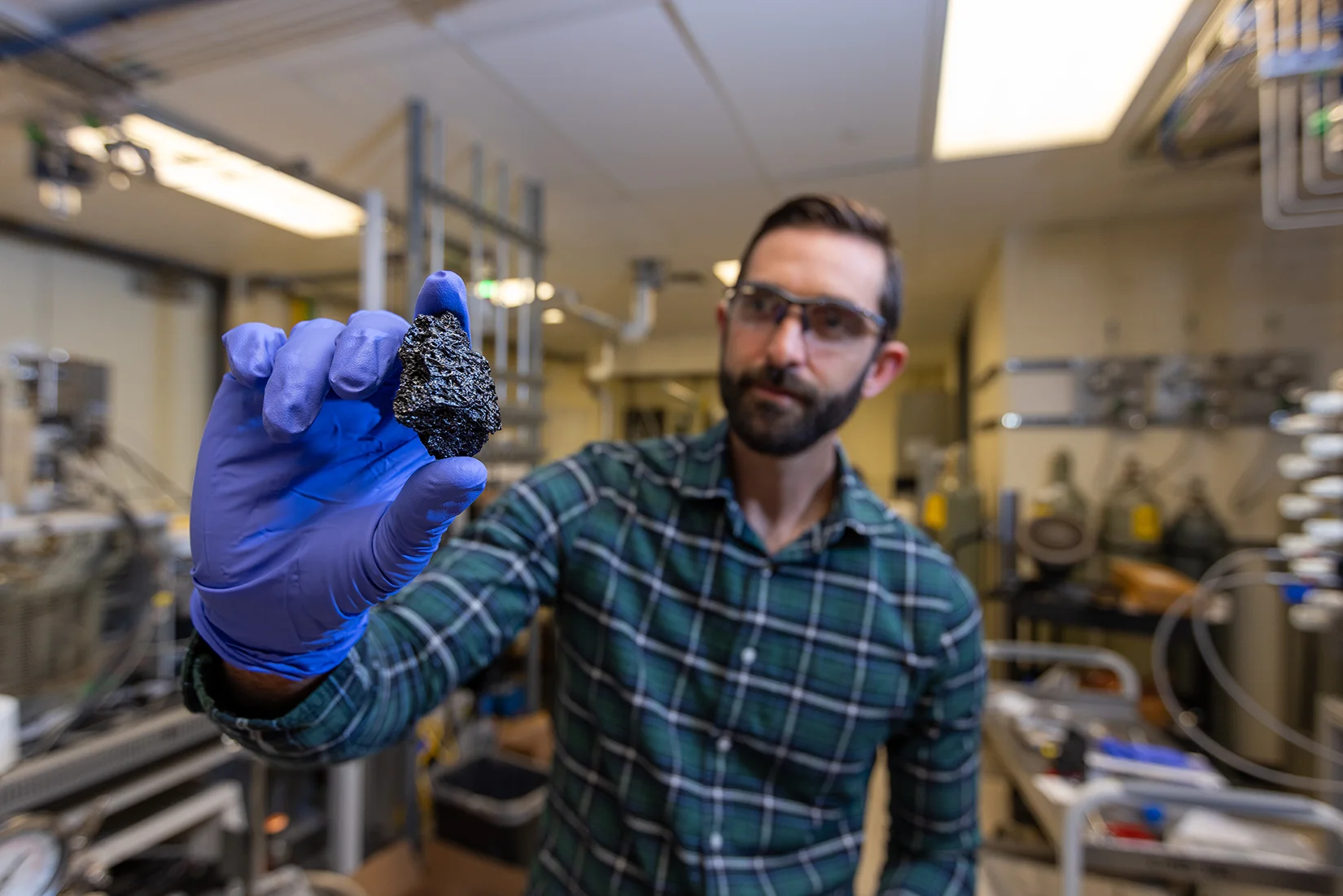 20260325-turning-biomass-into-graphite-could-help-secure-us-critical-mineral-supply-biographite-094303 A researcher holds a chunk of bio-coke.