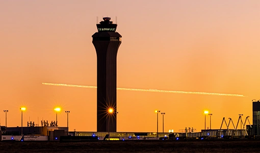 An airport air traffic control tower at sunset