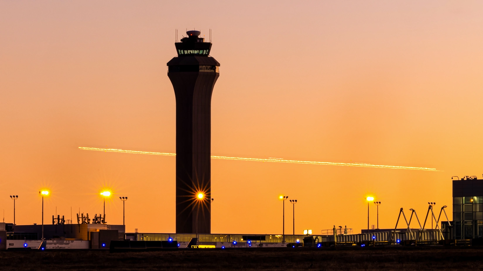 20260330-new-analysis-details-how-air-traffic-control-towers-can-maintain-operations-during-grid-outages-denver-airport-jeppesen_terminal_sunrise An airport air traffic control tower at sunset
