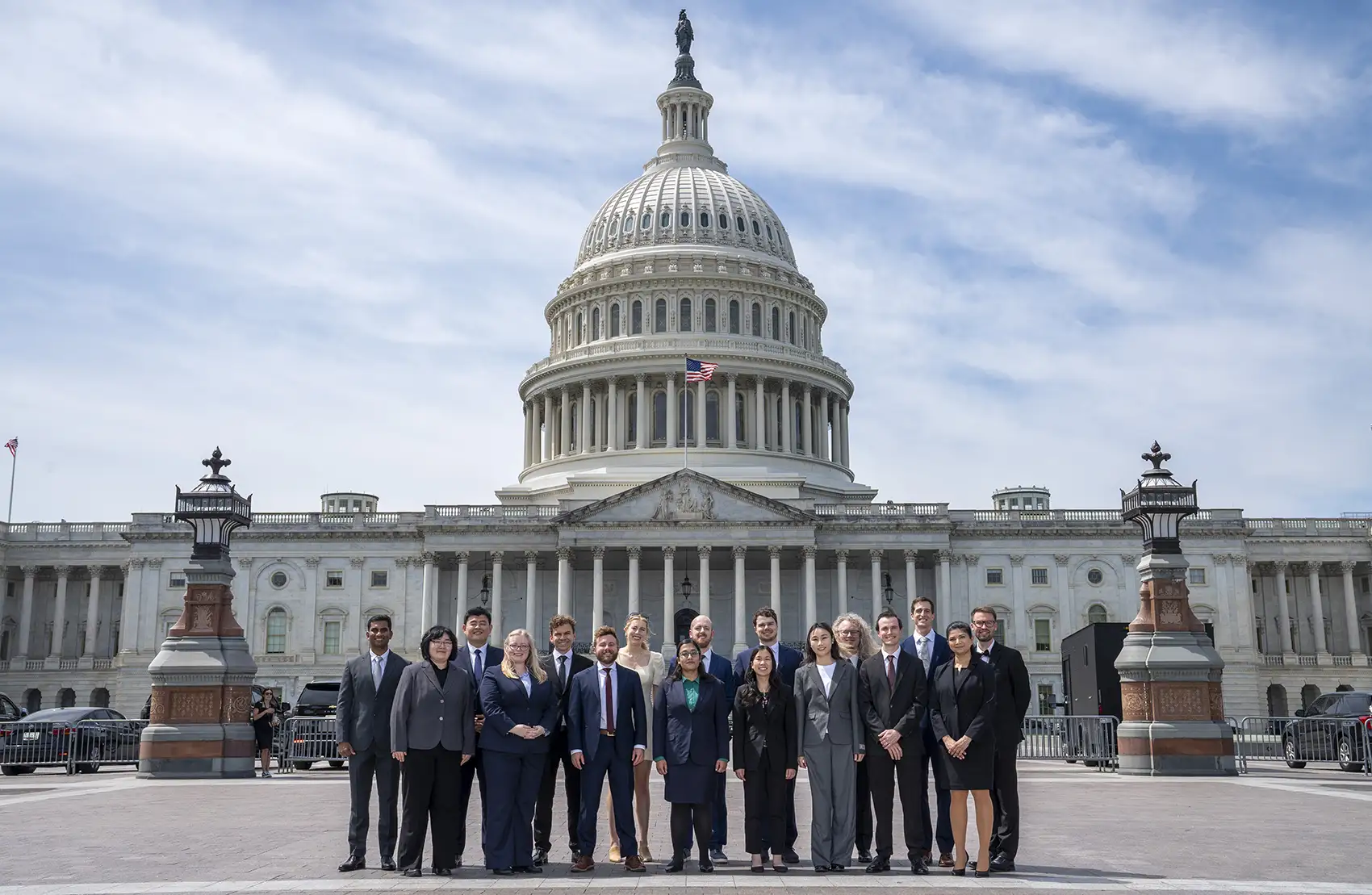 A group of people stand in front of the United States Capitol