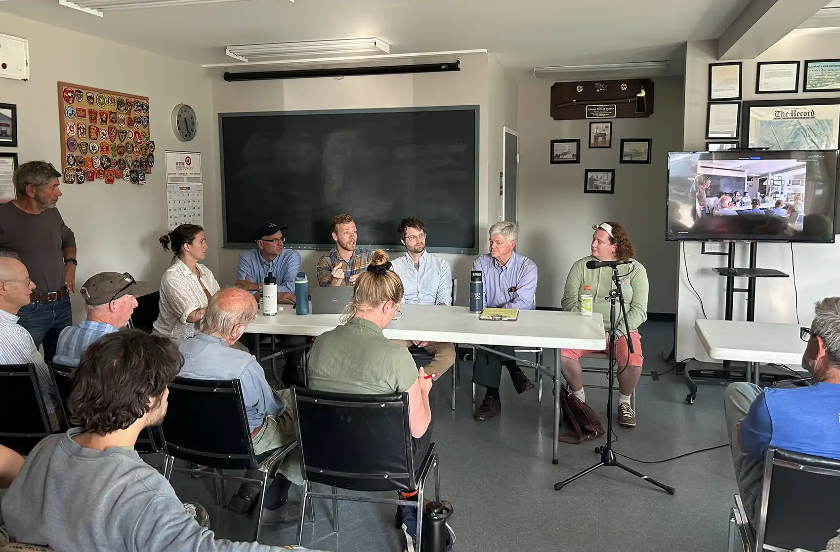 20260813-move-local-energy-goals-forward-apply-to-the-energy-technology-innovation-partnership-project-brooklin People sit in a room and face a table where six people are seated.