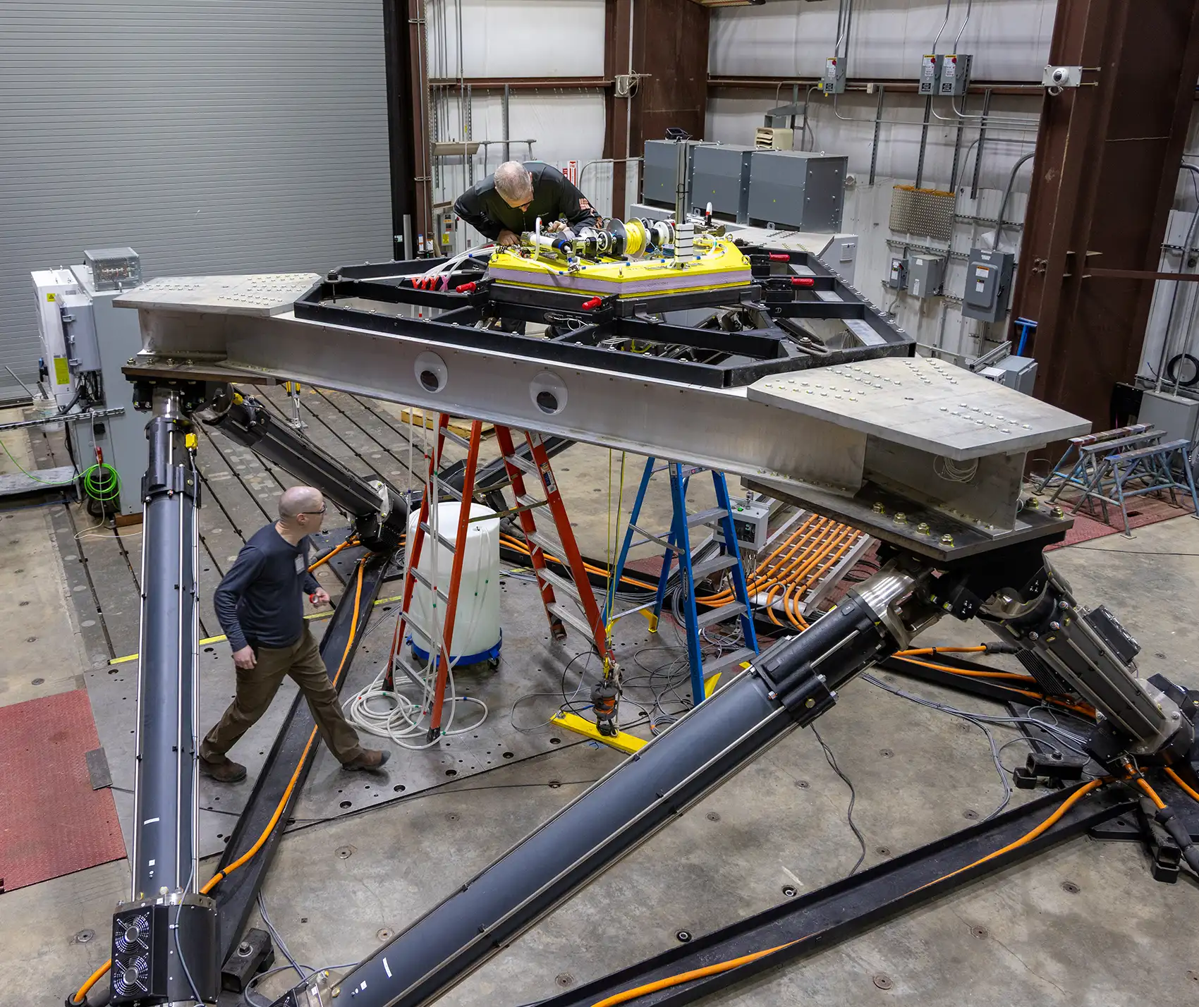 20260914-where-marine-energy-meets-hybrid-power-systems-this-laboratory-derisks-integration-104505 The large-amplitude motion platform with two people working on it.