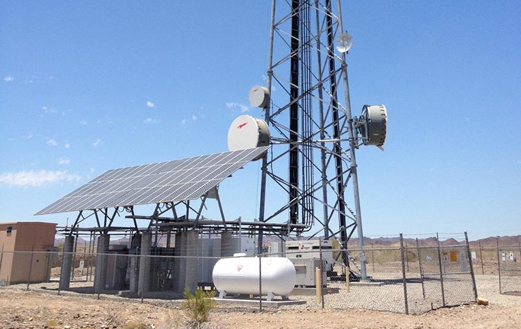 project-verizon Photo of a solar panel in front of a communications tower.