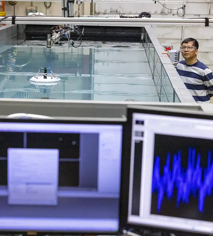 Researcher looks over wave tank test