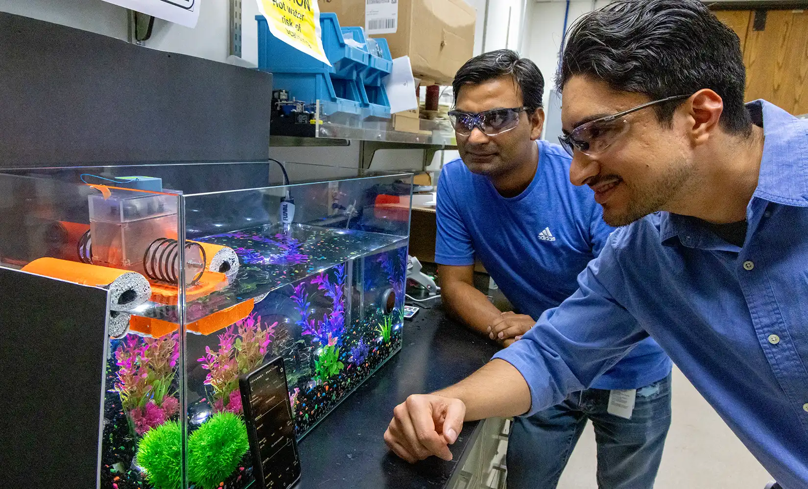 Two researchers examine thermomagnetic generator.