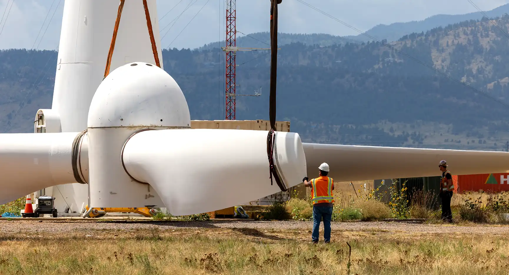 Worker stands in the field directing a wind turbine decommissioning project.