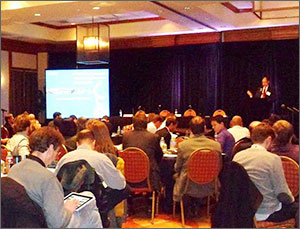 se_workshop_2013 Photo of a seated audience with a presenter at a podium and a projection screen in the background.